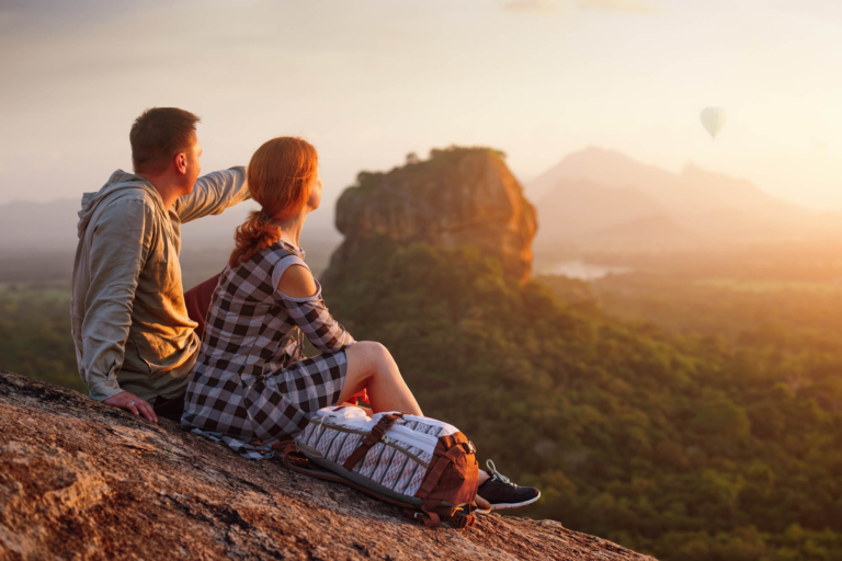 couple travelers watch beautiful sunset near famous rocky plateau Lion peak, Sigiriya. Sri Lanka
